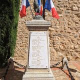 Le monument aux morts de Tresserre pavoisé.